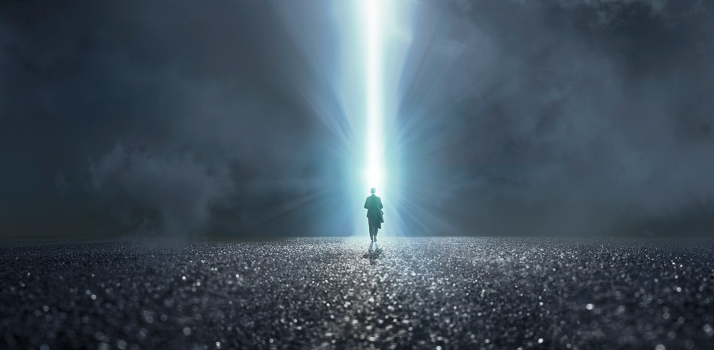 Person walking toward bright light symbolizing from despair to purpose journey of shadow transformation